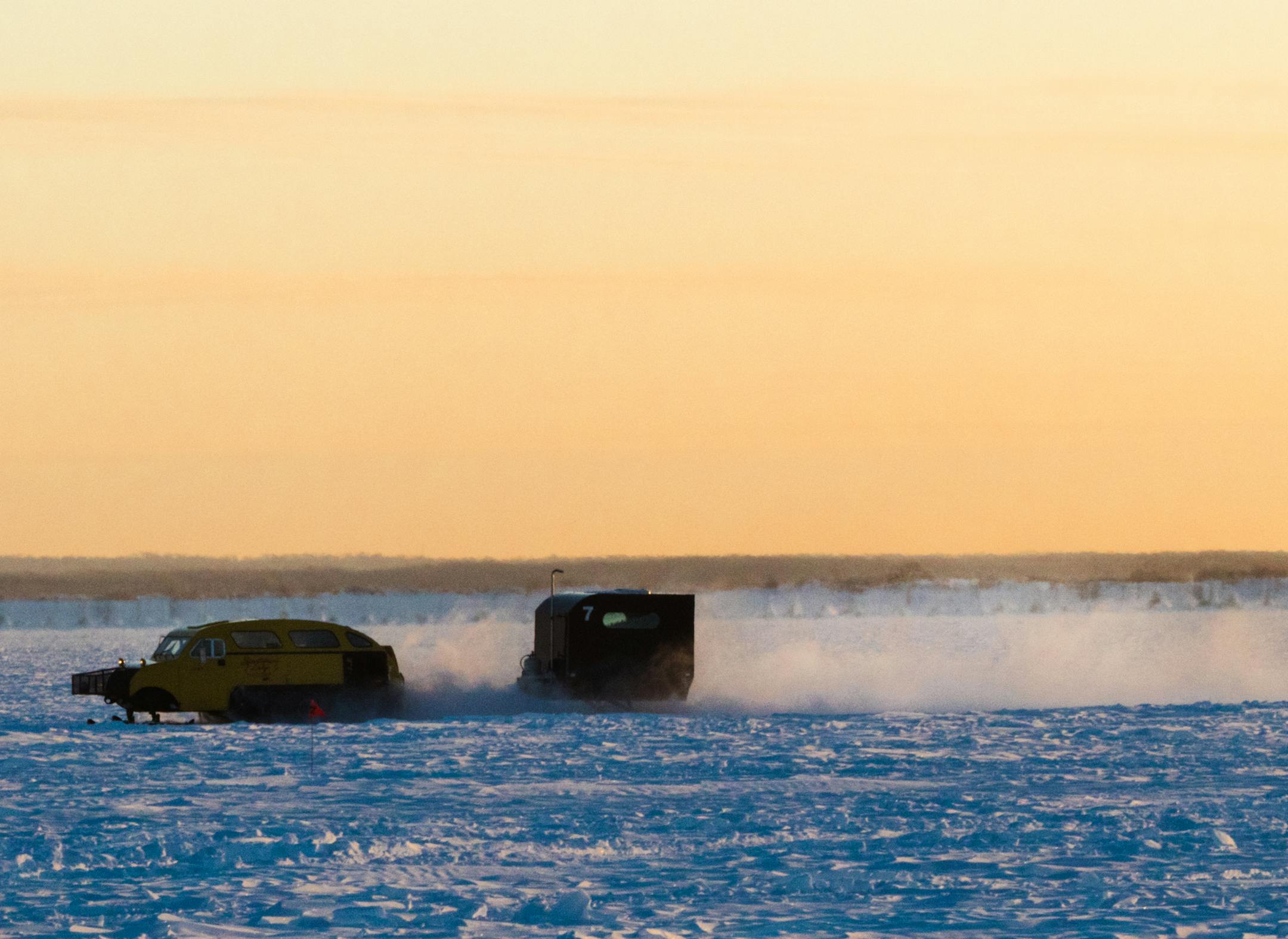 BAUDETTE, MINN. -January 7, 2017 - A bombardier cruises across the ice during sunrise on Lake of the Woods. The vehicles are equipped with tracks in the rear and skis in the front to make it easier to traverse snow drifts on the ice. Photo By: Matt Weber
