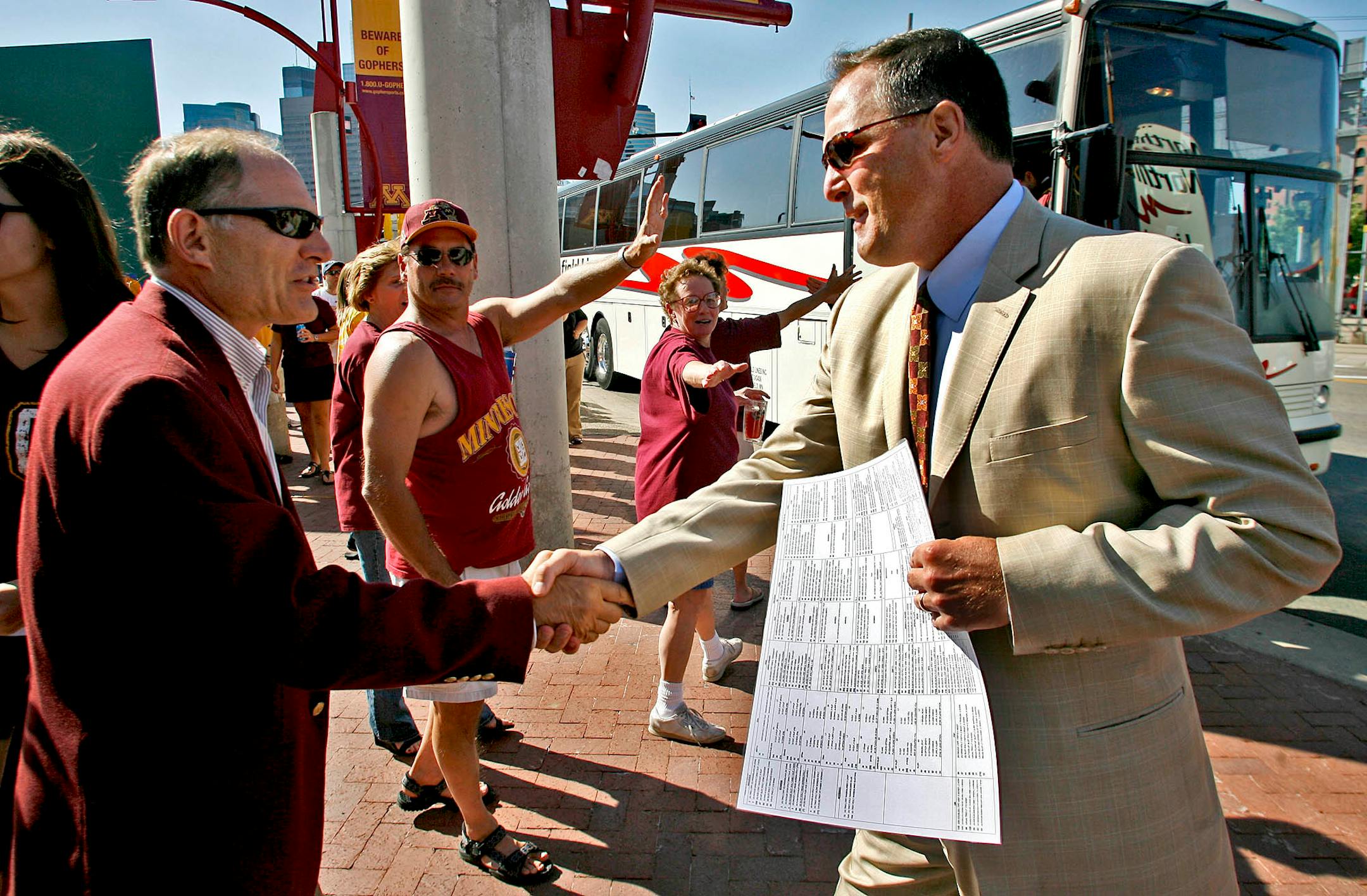 - GENERAL INFORMATION: UM football vs. Northern Illinois. Head coach Tim Brewster and players walk to the Metrodome for the first game in the final season in the downtown facility. N THIS PHOTO: UM athletic director Joel Maturi, left and coach Brewster greeted one other.