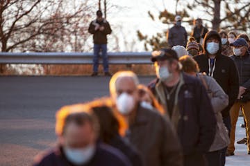 A long line of voters forms outside of First United Methodist Church as the sun rose over Lake Superior in Duluth, Minn., on Election Day, Tuesday, No