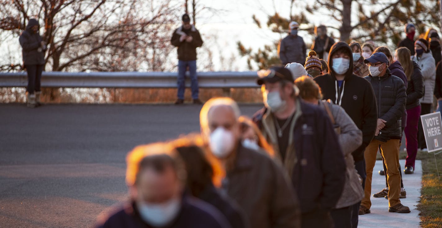 A long line of voters forms outside of First United Methodist Church as the sun rose over Lake Superior in Duluth, Minn., on Election Day, Tuesday, Nov. 3, 2020. (Alex Kormann/Star Tribune via AP)