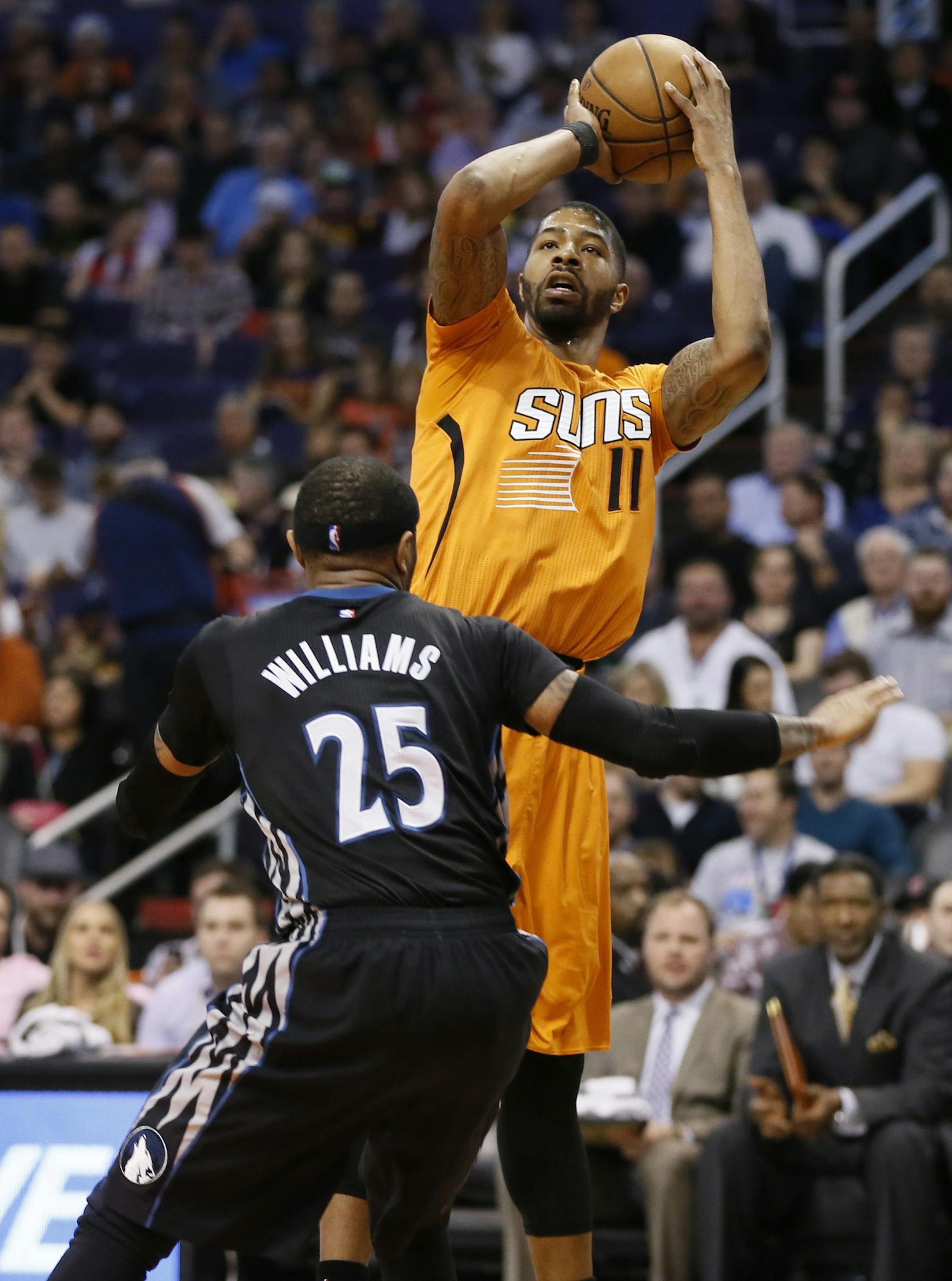Phoenix Suns' Markieff Morris (11) shoots over Minnesota Timberwolves' Mo Williams during the second half of an NBA basketball game, Friday, Jan. 16, 2015, in Phoenix. (AP Photo/Matt York)
