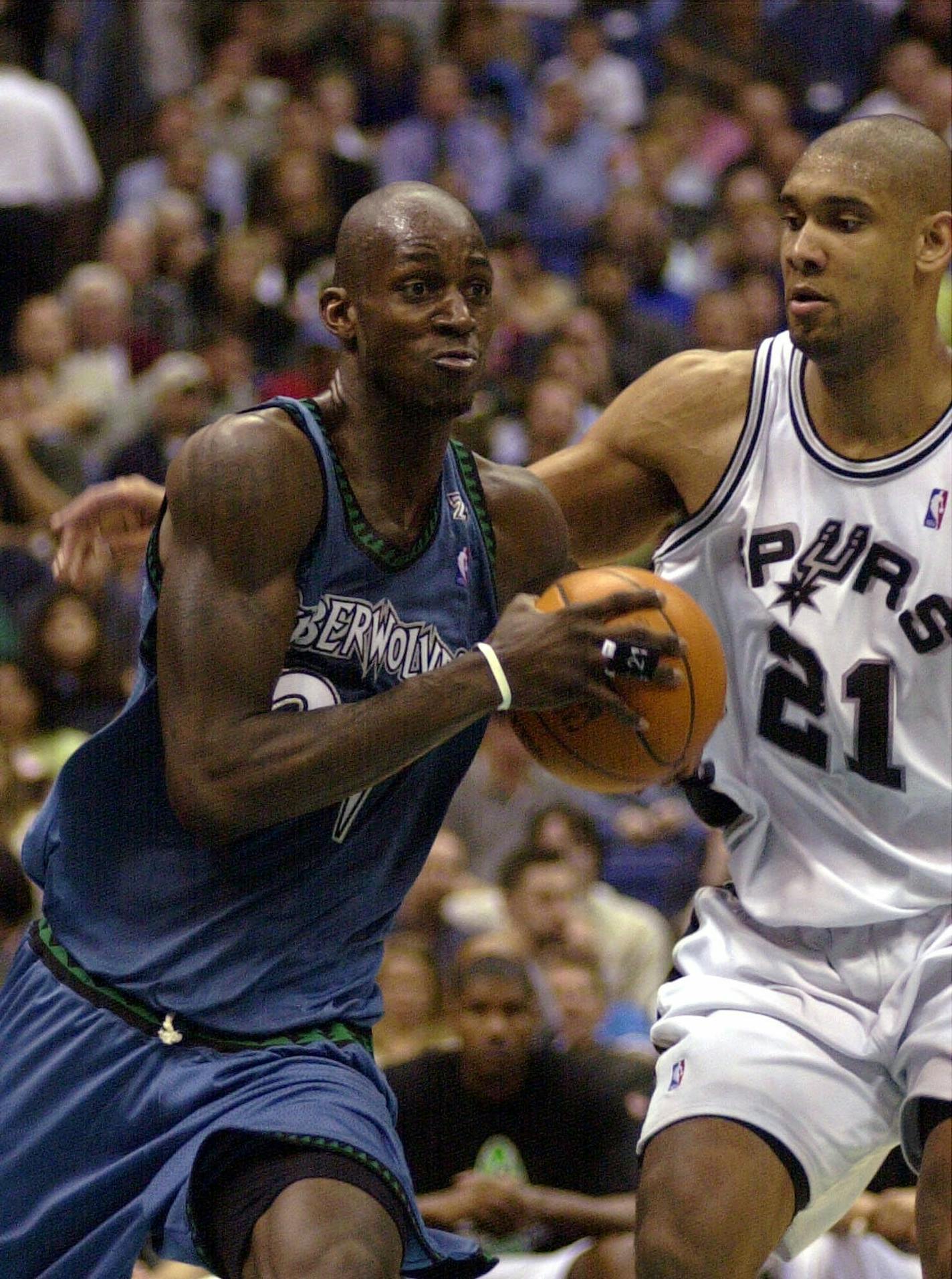 Minnesota Timberwolves' Kevin Garnett, left, drives against San Antonio Spurs' Tim Duncan (21) during the third quarter Wednesday, March 14 , 2001, at the Alamodome in San Antonio. The Spurs won in overtime, 106-100. (AP Photo/Joe Cavaretta)