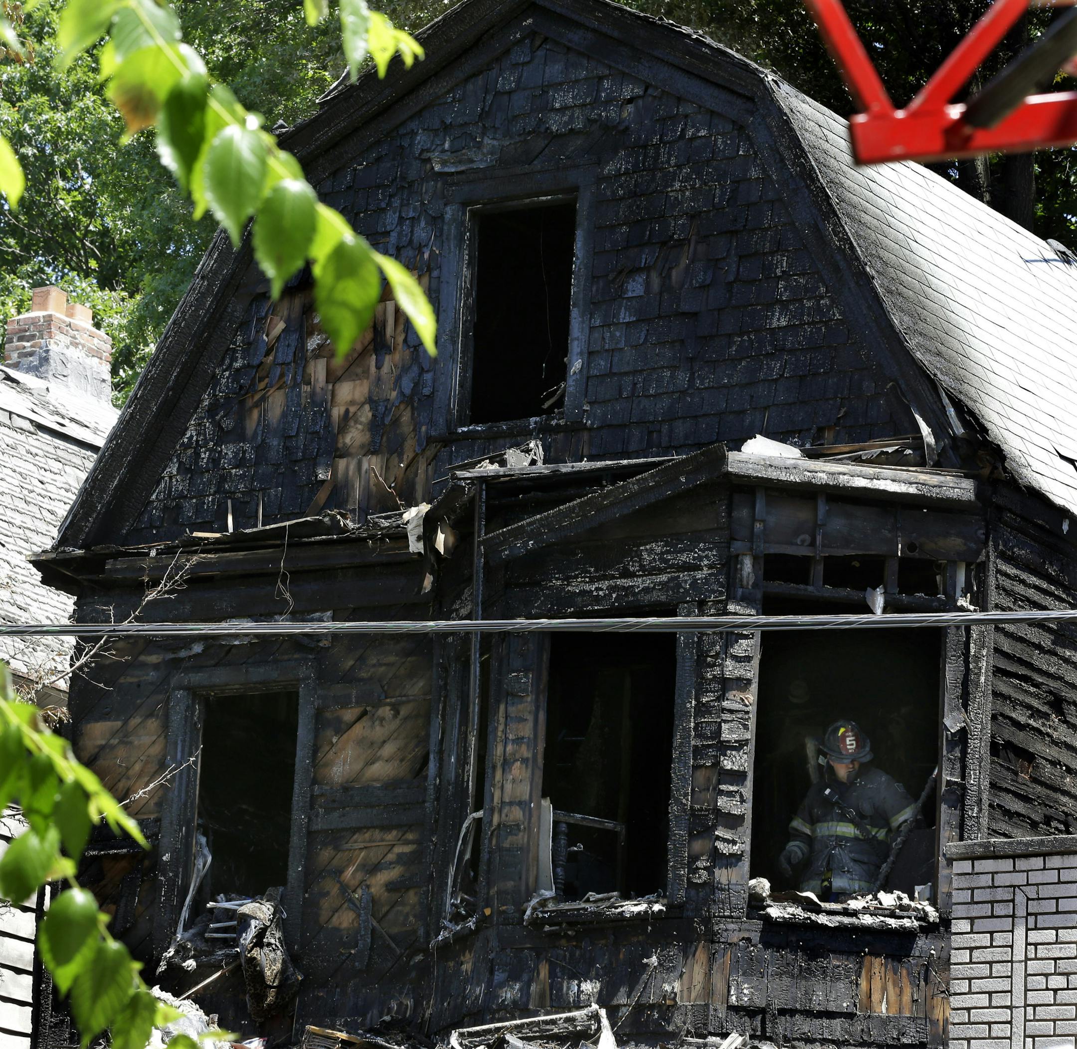Firefighters pick through the rubble of a burned out home as they look for clues to a fire that authorities say killed six people in Newark, N.J., Sunday, June 15, 2014. The Essex County prosecutor's office says the fast-moving fire that roared through a single-family home in New Jersey's largest city, broke out at around 4 a.m. Sunday. (AP Photo/Mel Evans)