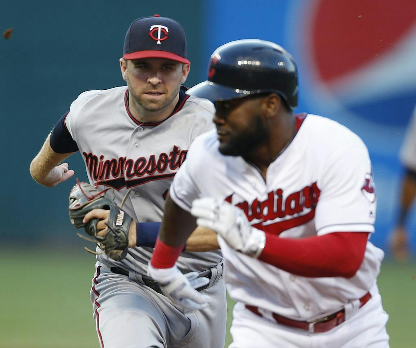 Minnesota Twins' Brian Dozier chases down Cleveland Indians' Abraham Almonte in a rundown between first and second bases during the second inning of a baseball game Wednesday, Aug. 3, 2016, in Cleveland. Dozier made the tag for the out.