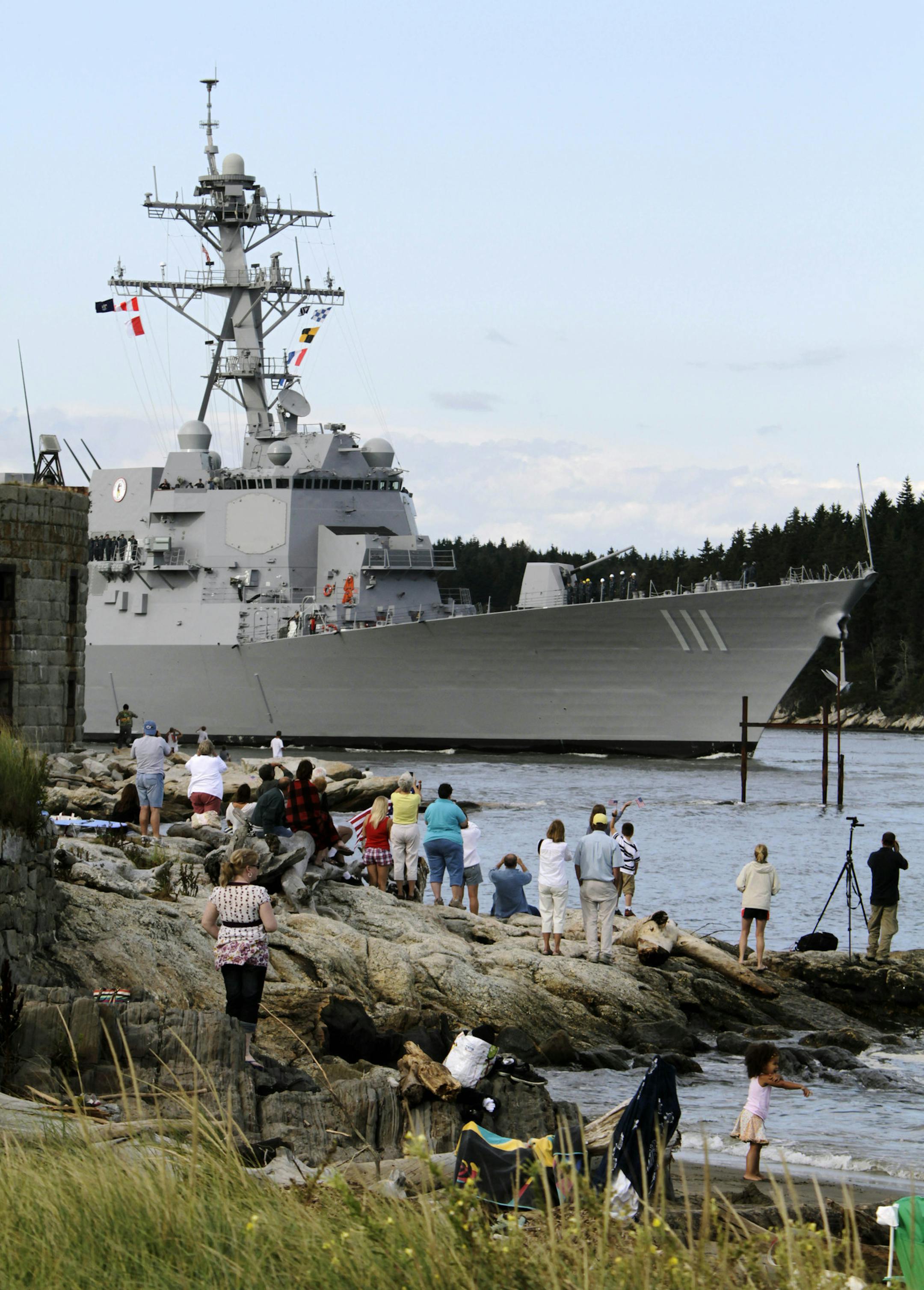 People greet the US Navy Destroyer, Spruance, as it passes Fort Popham in Phippsburg, Maine on its way from Bath Iron Works in Bath, Maine to her commissioning at Key West, Florida in late October, on Thursday, Sept. 1, 2011. (AP Photo/Pat Wellenbach) ORG XMIT: MEPW103