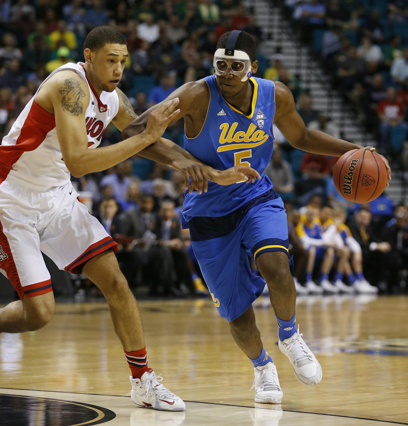 UCLA's Kevon Looney drives around Arizona's Brandon Ashley during the first half of an NCAA college basketball game in the semifinals of the Pac-12 conference tournament Friday, March 13, 2015, in Las Vegas. (AP Photo/John Locher)