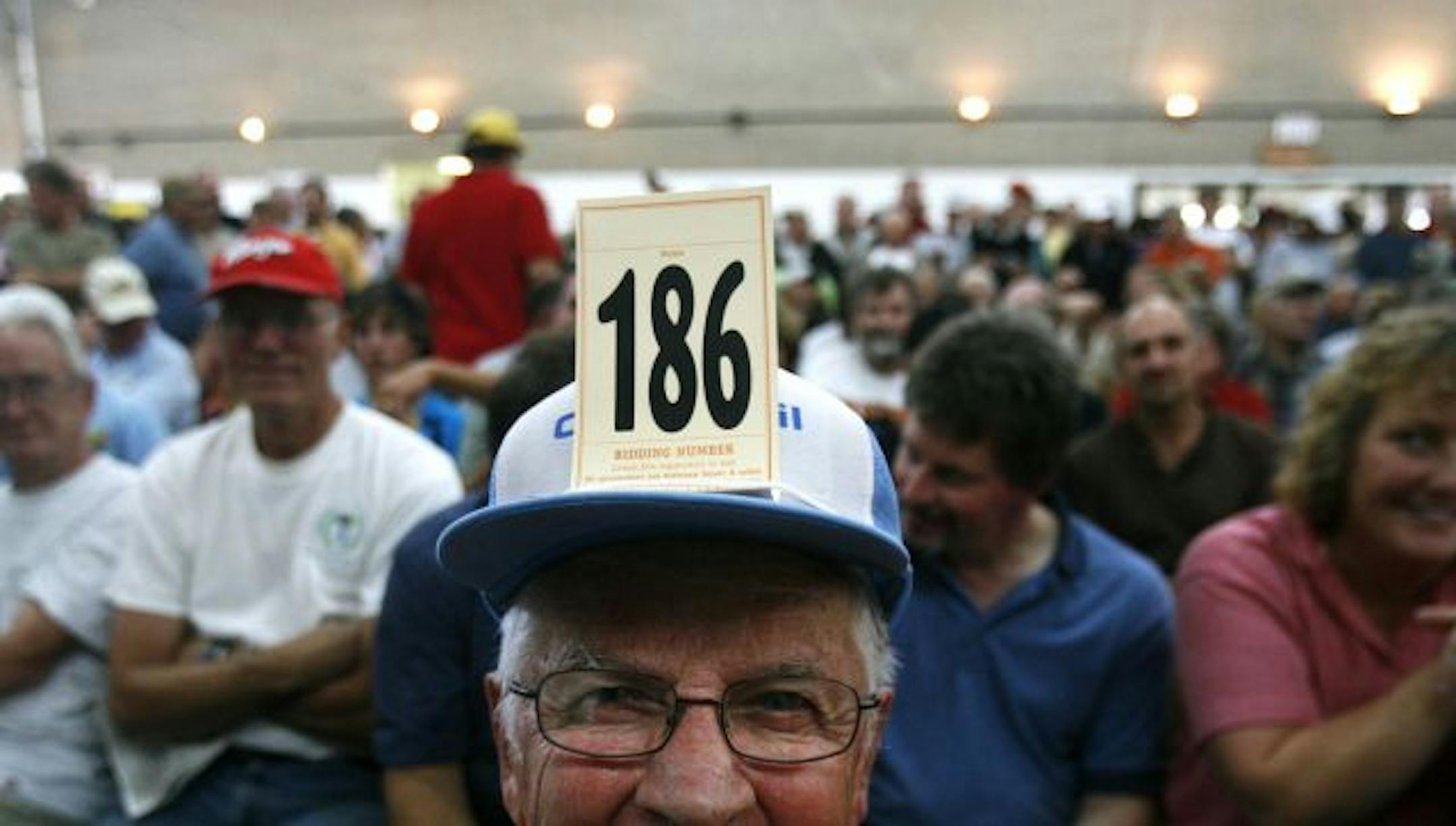 Art Fuchs of Young America wore his bidding number on his hat as he joined a large crowd and waited to bid on golf clubs once owned by Denny Hecker.