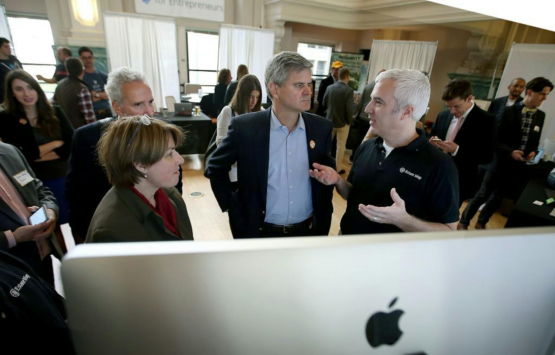 AOL.com founder and startup-business promoter Steve Case, center, and Senator Amy Klobuchar, left, listened to Joe Henderson's business pitch at CoCo's "startup fair," Tuesday, October 7, 2014 at the former Grain Exchange floor in downtown Minneapolis, MN.