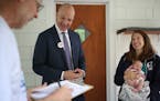 Nick Faber, president of the St. Paul teachers union, left, and Superintendent Joe Gothard spoke with Keely Young-Dixon who held her 1-week-old daught