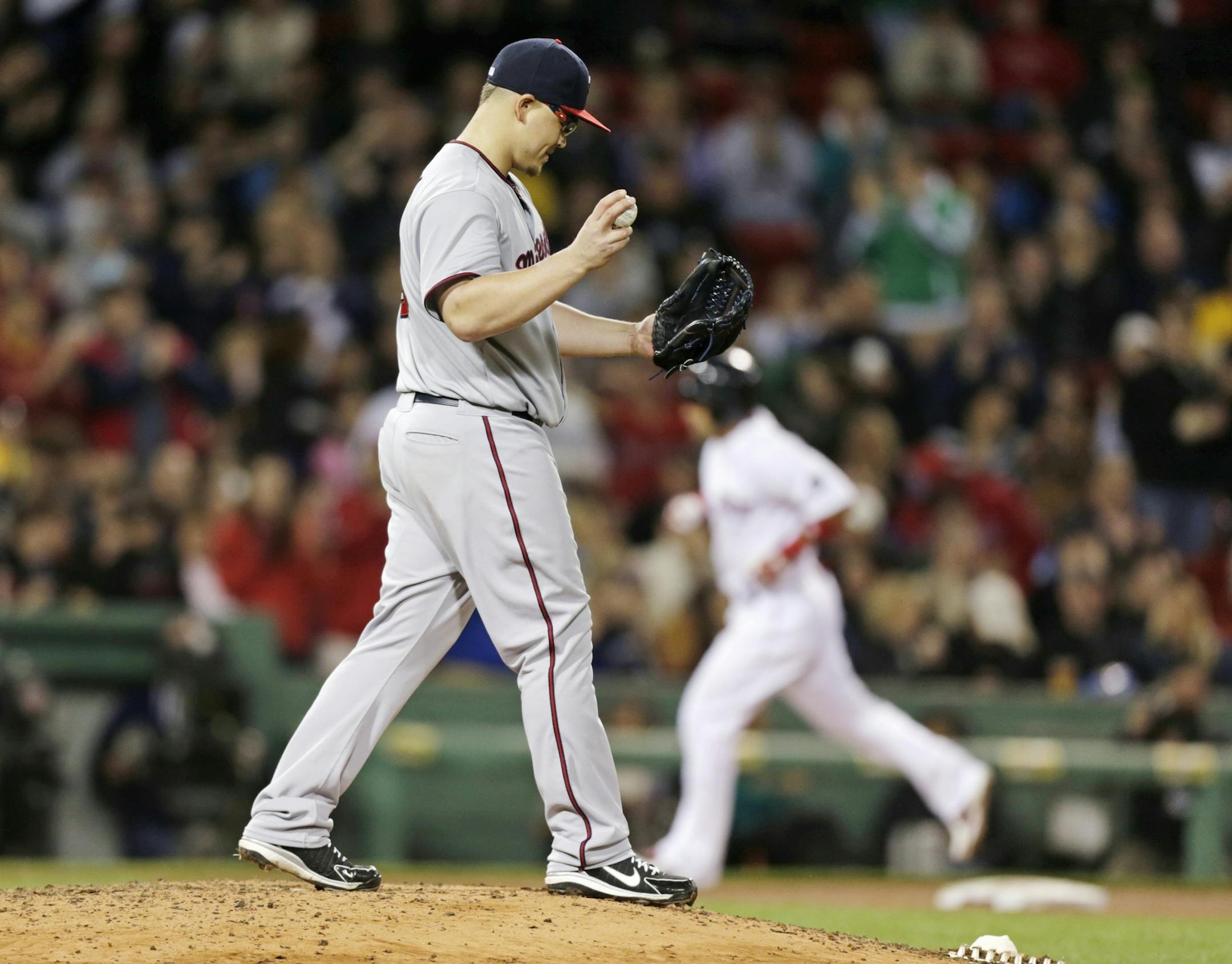 Vance Worley walks over the mound as Shane Victorino rounds the bases after his solo home run during the fourth inning of a baseball game at Fenway Park