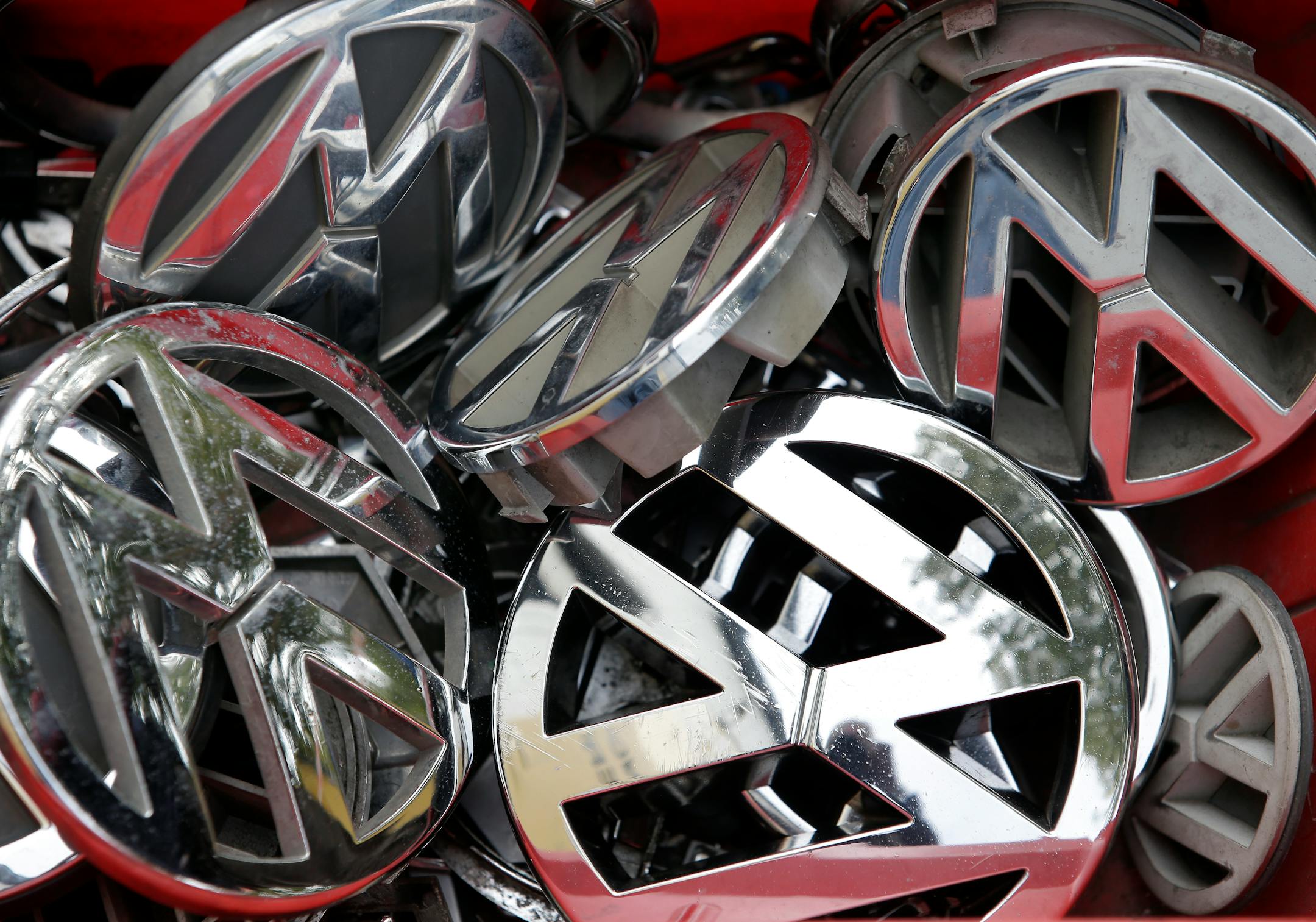 Company logos of the German car manufacturer Volkswagen sit in a box at a scrap yard in Berlin, Germany, Wednesday, Sept. 23, 2015. (AP Photo/Michael Sohn)