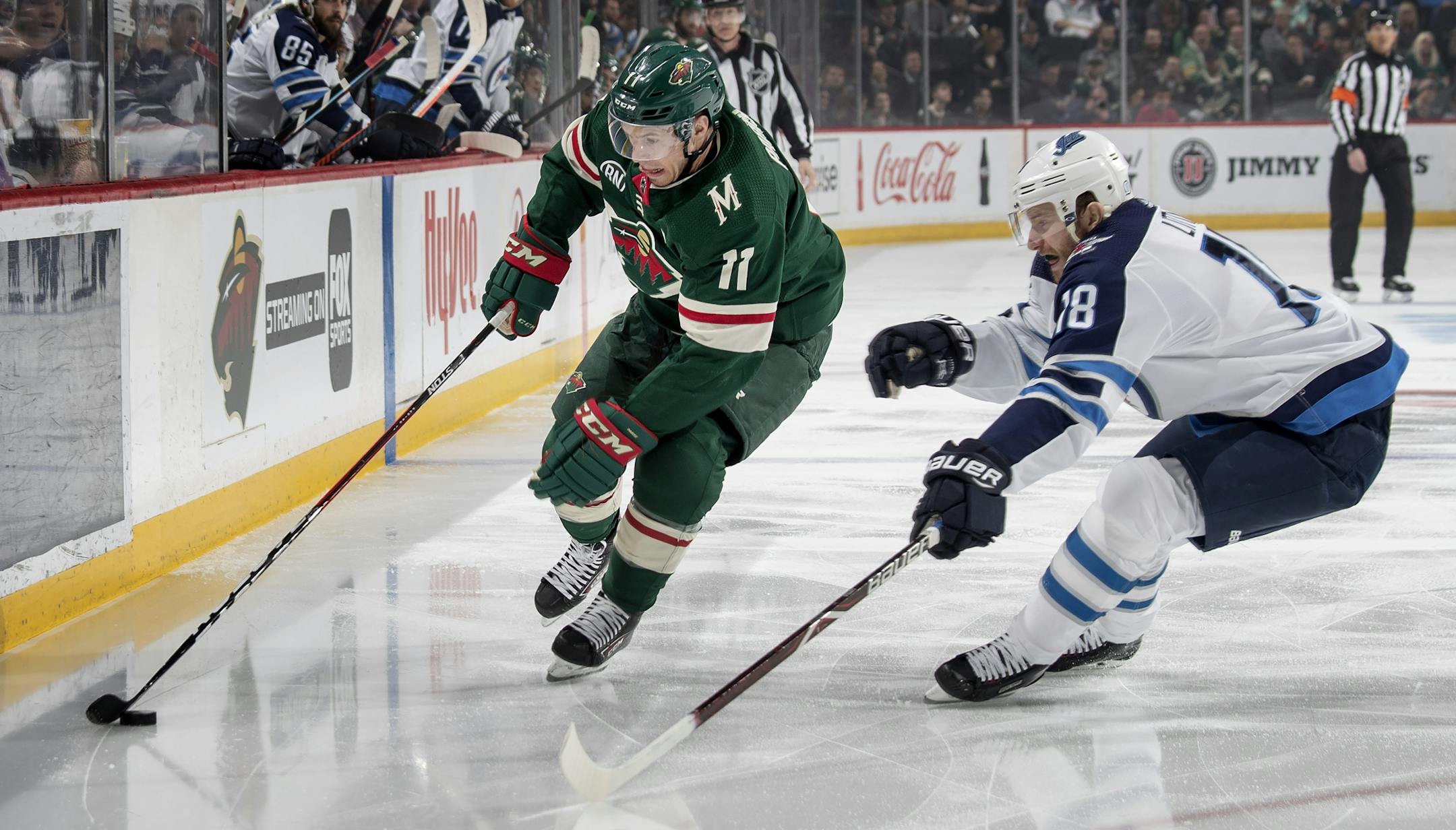 Zach Parise (11) and Bryan Little (18) fought for the puck in the first period.