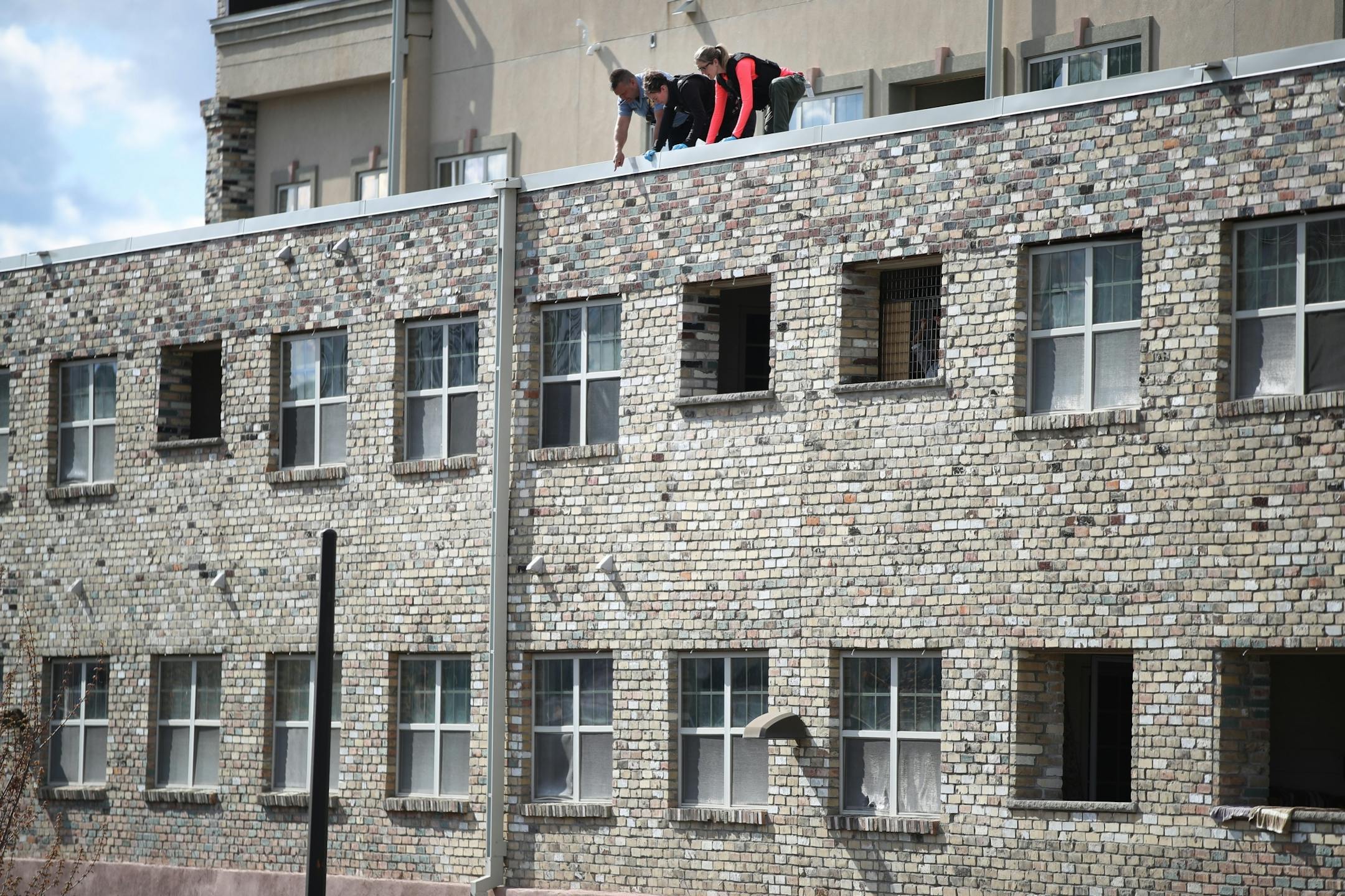 Minneapolis police officers and crime lab investigators looked over the scene after two children fell from an apartment building at S. 28th and Pleasant Avenue on Thursday in Minneapolis
