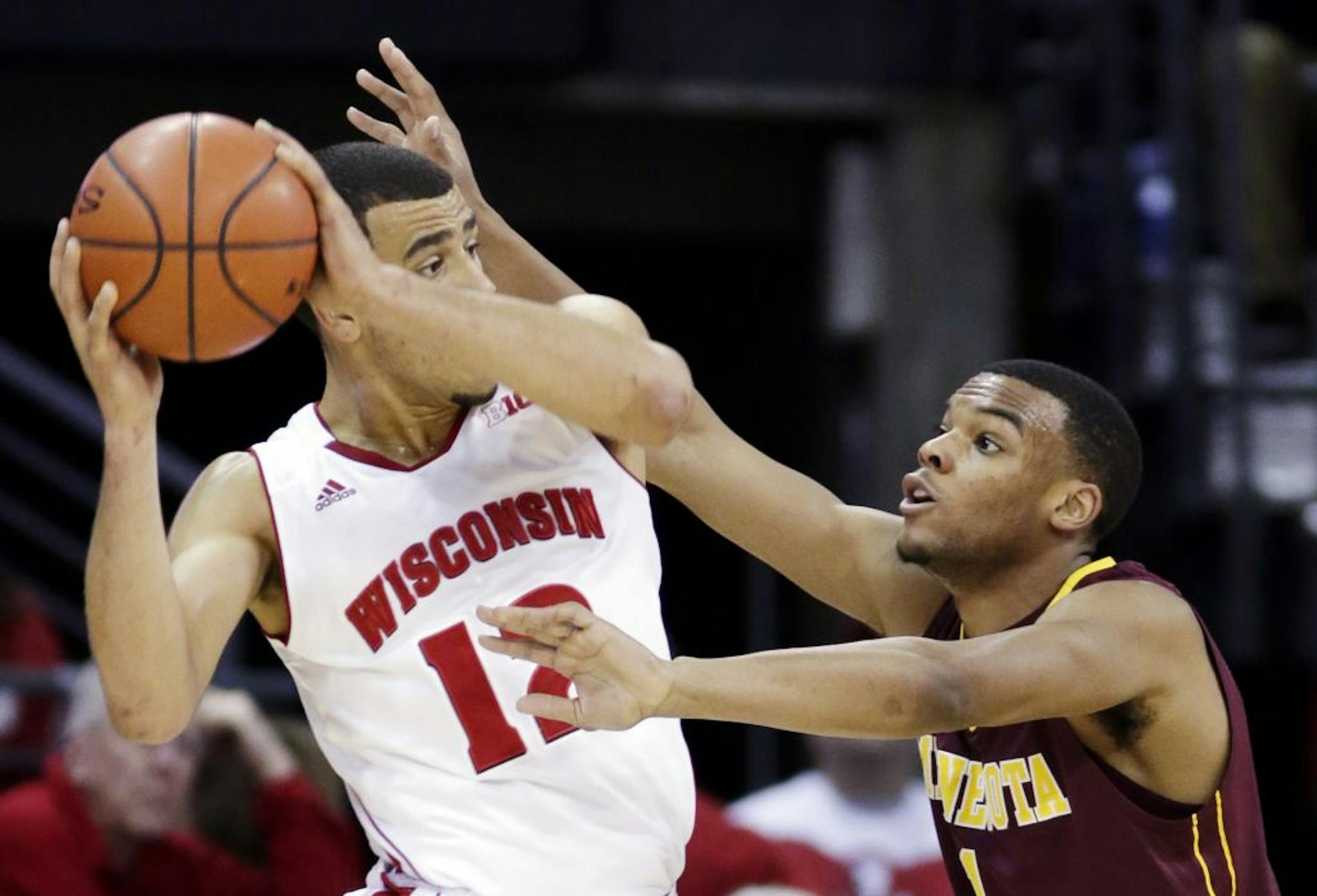 Minnesota's Andre Hollis, right, reaches in on Wisconsin's Traevon Jackson during the first half of an NCAA college basketball game, Saturday, Jan. 26, 2013, in Madison, Wis.