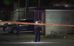 A St. Paul Police officer photographed evidence at the scene of a double shooting in a parking lot off Pascal St. in St. Paul Sunday night.
