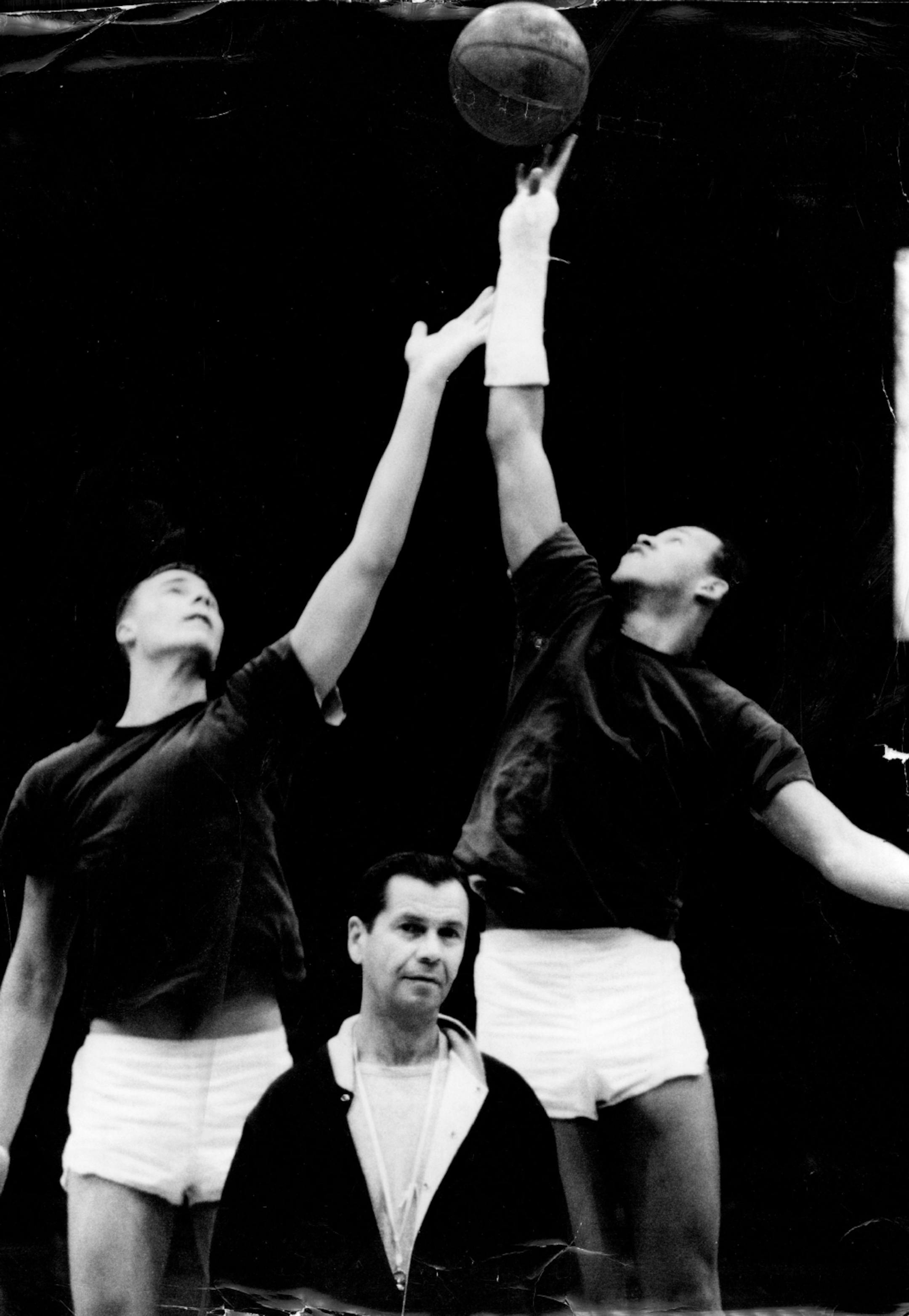 January 14, 1966 Lou's Back Louis Hudson, Minnesota basketball star who has been out nearly a month with a fractured wrist, makes a right-handed "cast" tap against center Tom Kondla (left) in practice. Gopher coach John Kundla is in foreground. Hudson is expected to play at least part-time when Minnesota hosts ' Indiana Saturday night. January 13, 1966 United Press International