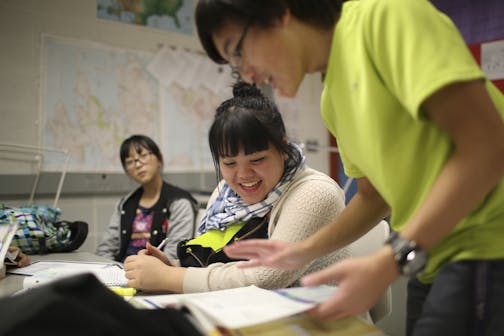 T.C. Vang filled in Michelle Vang on their health homework as they studied with other Upward Bound program students after school Wednesday at Brooklyn Center High School.