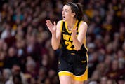 Caitlin Clark cheers on a teammate during the Hawkeyes' rout of the Gophers last week at Williams Arena. She returns Wednesday to Minneapolis for the 