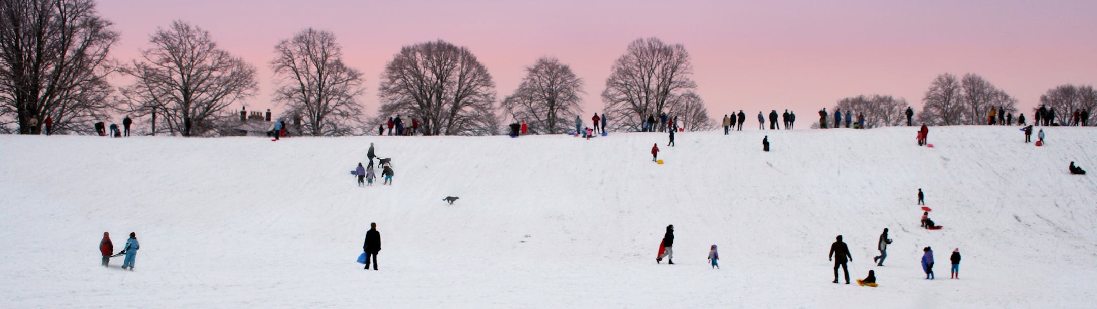 iStock
"Snowman in forground has his back to the action with Late Afternoon Family Fun in the snow against a stunning sky.