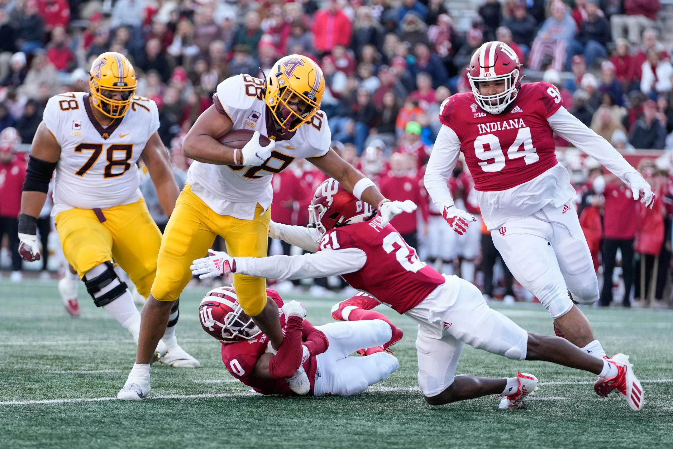 Minnesota tight end Brevyn Spann-Ford (88) is tackled by Indiana defenders Raheem Layne II (0) and Noah Pierre (21) in the first half during an NCAA college football game in Bloomington, Ind., Saturday, Nov. 20, 2021. (AP Photo/AJ Mast)