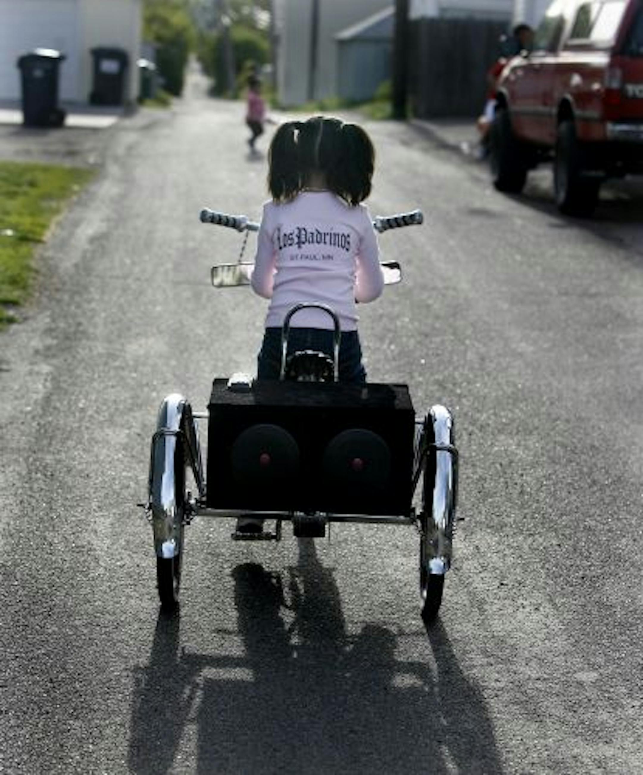 Lowriders, the next generation: Karon Macias, 6, of West St. Paul, pedals off on the "Pink Panther"-themed junior lowrider her father built.