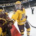 Minnesota Golden Gophers defenseman Jake Bischoff (28) bumped fists with teammates before the start of the second period Friday night against the Ohio