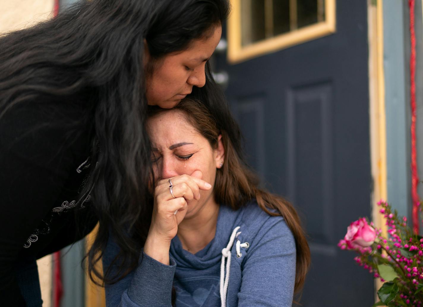 Martha Perea was comforted by a friend while clutching a photo of her husband on the steps of the house where the couple lived. Martha Perea's husband, Jose Angel Madrid Salcido, was killed when a driver fleeing police struck his car Wednesday night.