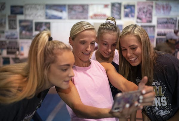 Coach Sarah Jantzi held her phone to show a photo that was just taken of gymnasts Maggie Nichols, Grace McCallum, and Olivia Trautman, from left, afte