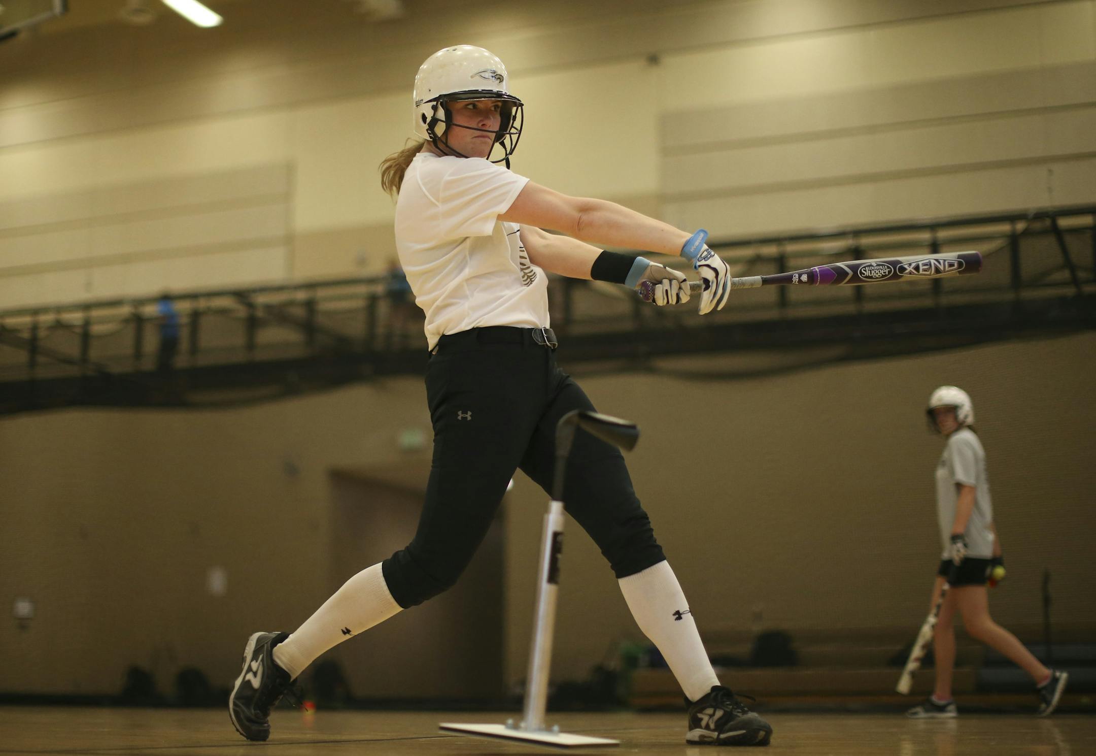 Olivia Huffman batted off a tee during practice at East Ridge High School Tuesday afternoon. ] JEFF WHEELER ï jeff.wheeler@startribune.com The East Ridge High School softball team practiced in the gym after school Tuesday afternoon, March 24, 2015.
