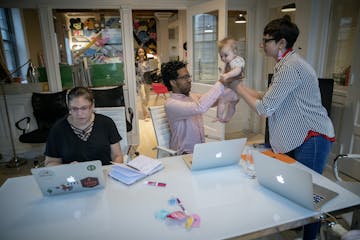 Pollen Midwest employee Jerome Rankine, center, handed off 6-month-old Dani to her mother Jamie Millard, Executive Director of Pollen Midwest, before 