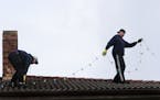 Employee Madison Murray, left, and Rob Johnston, owner of Clear N' Bright Windows, work to install holiday lights in Sultan, Wash. Thursday, Nov. 29, 