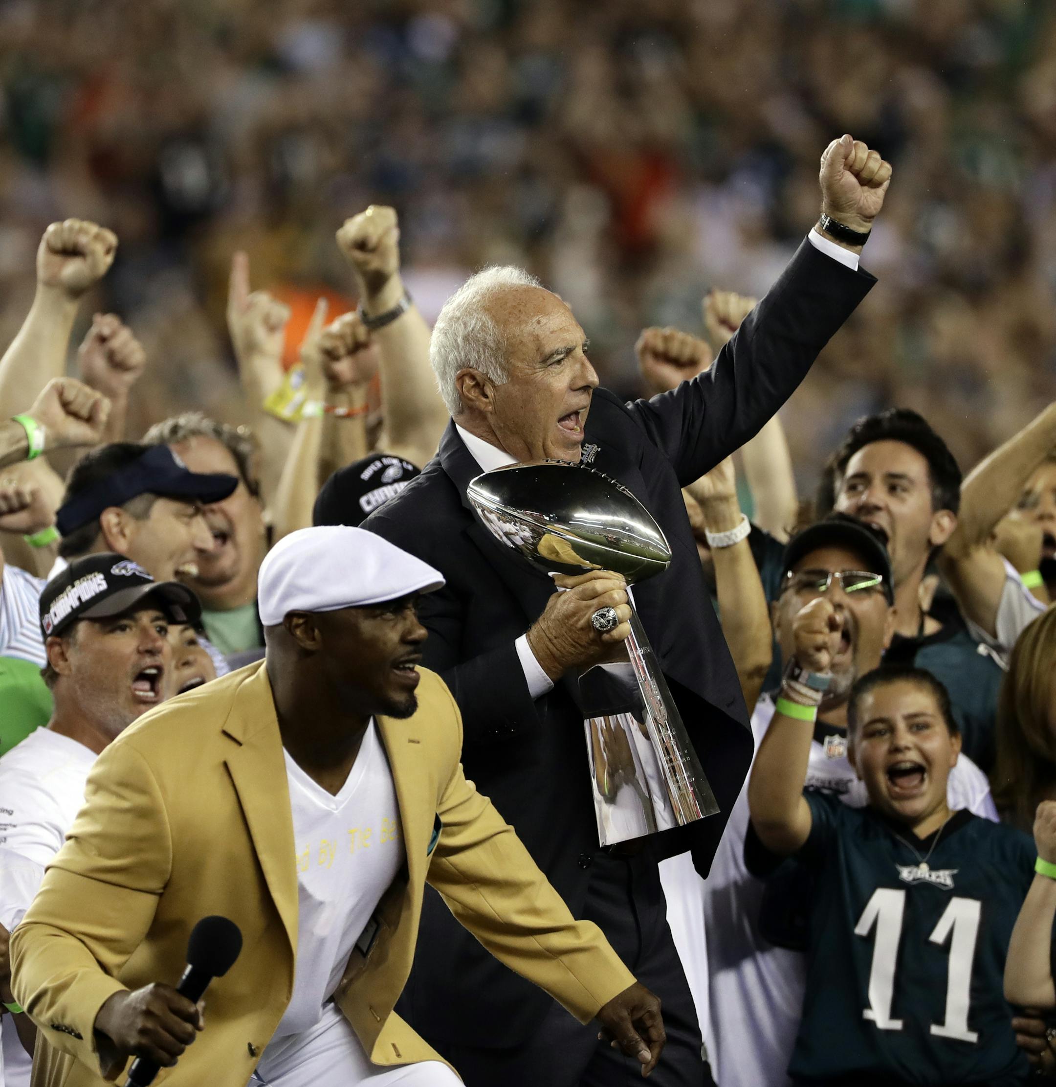 Philadelphia Eagles' Jeffrey Lurie reacts alongside Brian Dawkins during a ceremony before an NFL football game against the Atlanta Falcons , Thursday, Sept. 6, 2018, in Philadelphia. (AP Photo/Michael Perez)