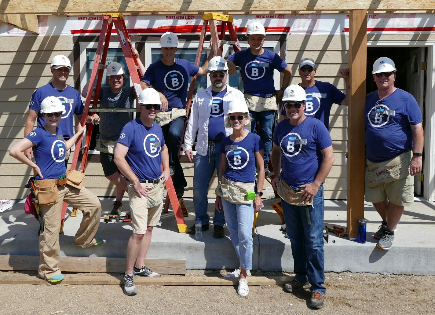 A photo of Jeanne and her Senior Executive Team during a Habitat Build (Jeanne is front row, second from right)