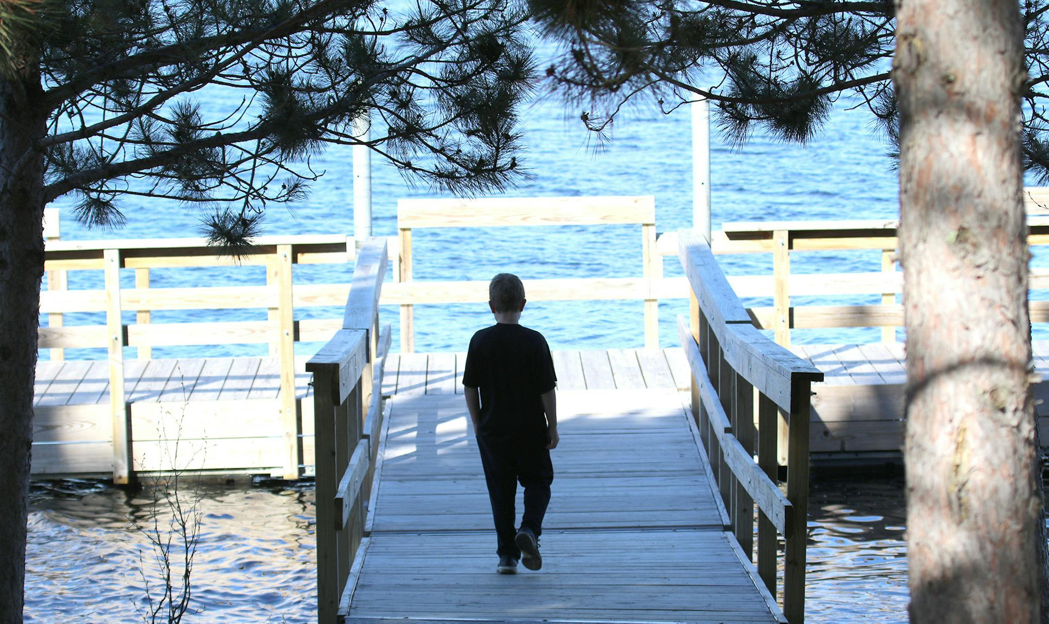 A visitor to the recently opened day-use area at Lake Vermilion-Soudan Underground Mine State Park checks out the fishing pier. Old-growth pine trees adorn this area of the park, also equipped with a large picnic shelter and vault toilets