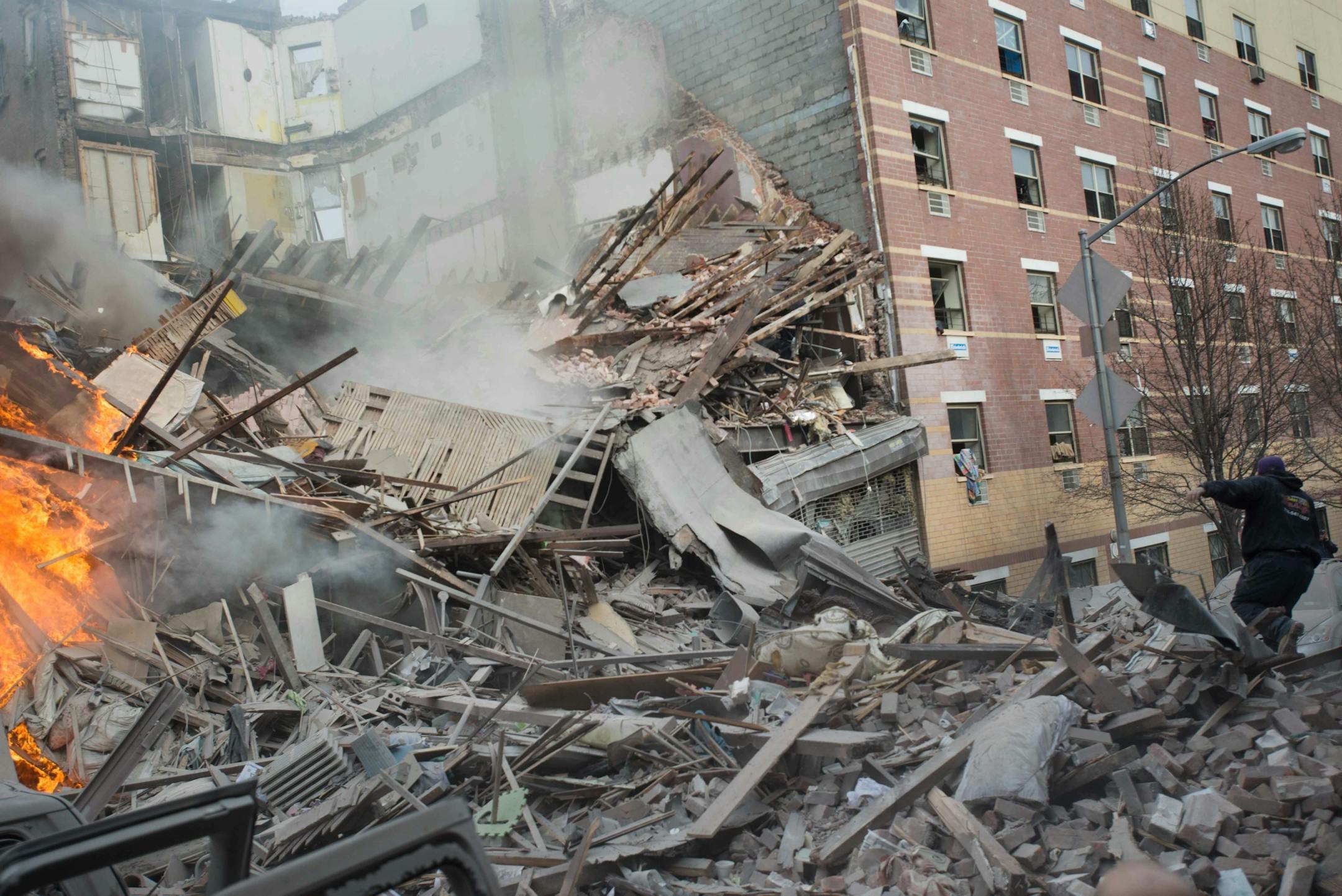 Emergency workers respond to the scene of an explosion and building collapse in the East Harlem neighborhood of New York, Wednesday, March 12, 2014. The explosion leveled an apartment building, and sent flames and billowing black smoke above the skyline.