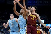 Indiana State's Jayson Kent (20) and the Gophers' Braeden Carrington (4) reach for a rebound during the second round of the NIT on Sunday in Terre Hau