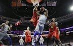 Philadelphia 76ers' Jimmy Butler (23) goes up for a shot between Atlanta Hawks' Omari Spellman (6) and DeAndre' Bembry (95) during the first half of a