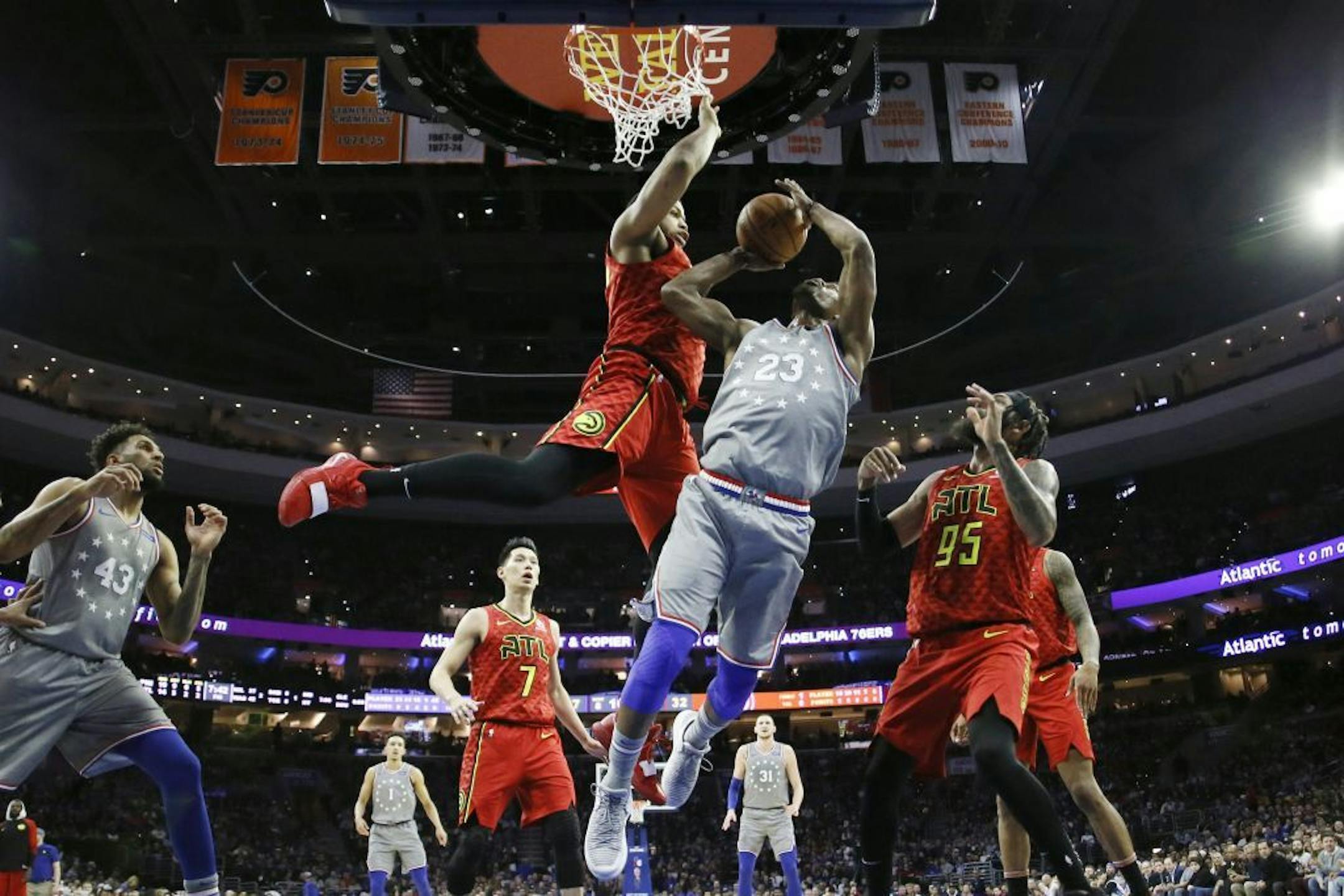 Philadelphia 76ers' Jimmy Butler (23) goes up for a shot between Atlanta Hawks' Omari Spellman (6) and DeAndre' Bembry (95) during the first half of an NBA basketball game Friday, Jan. 11, 2019, in Philadelphia.