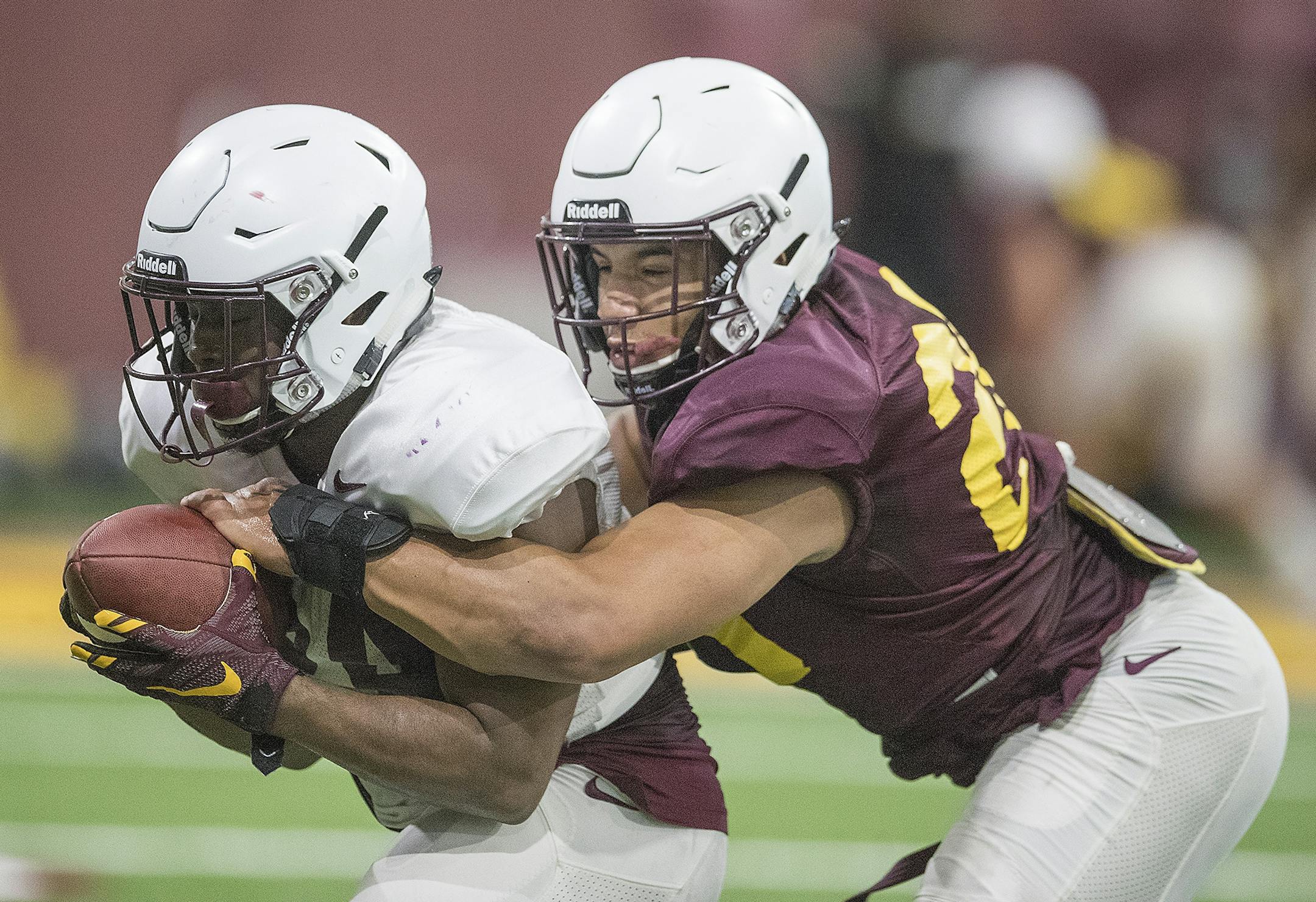 Minnesota's linebacker Julian Huff, right, tackled Mohamed Ibrahim as they took to the field for the first practice that was open to the public at the Athletes Village at the University of Minnesota in Minneapolis, MN.