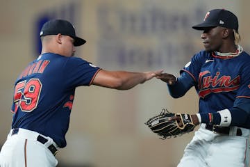 Minnesota Twins relief pitcher Jhoan Duran (59) celebrates with Minnesota Twins left fielder Nick Gordon (1).