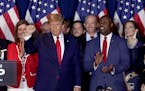 Former President Donald Trump gestured to supporters as Sen. Tim Scott (R-SC) applauded after Trump spoke Saturday in Columbia, S.C.