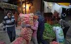 A laborer carries a sack of vegetables in Lucknow, capital of northern Indian state of Uttar Pradesh, Thursday, Feb. 29 2024.
