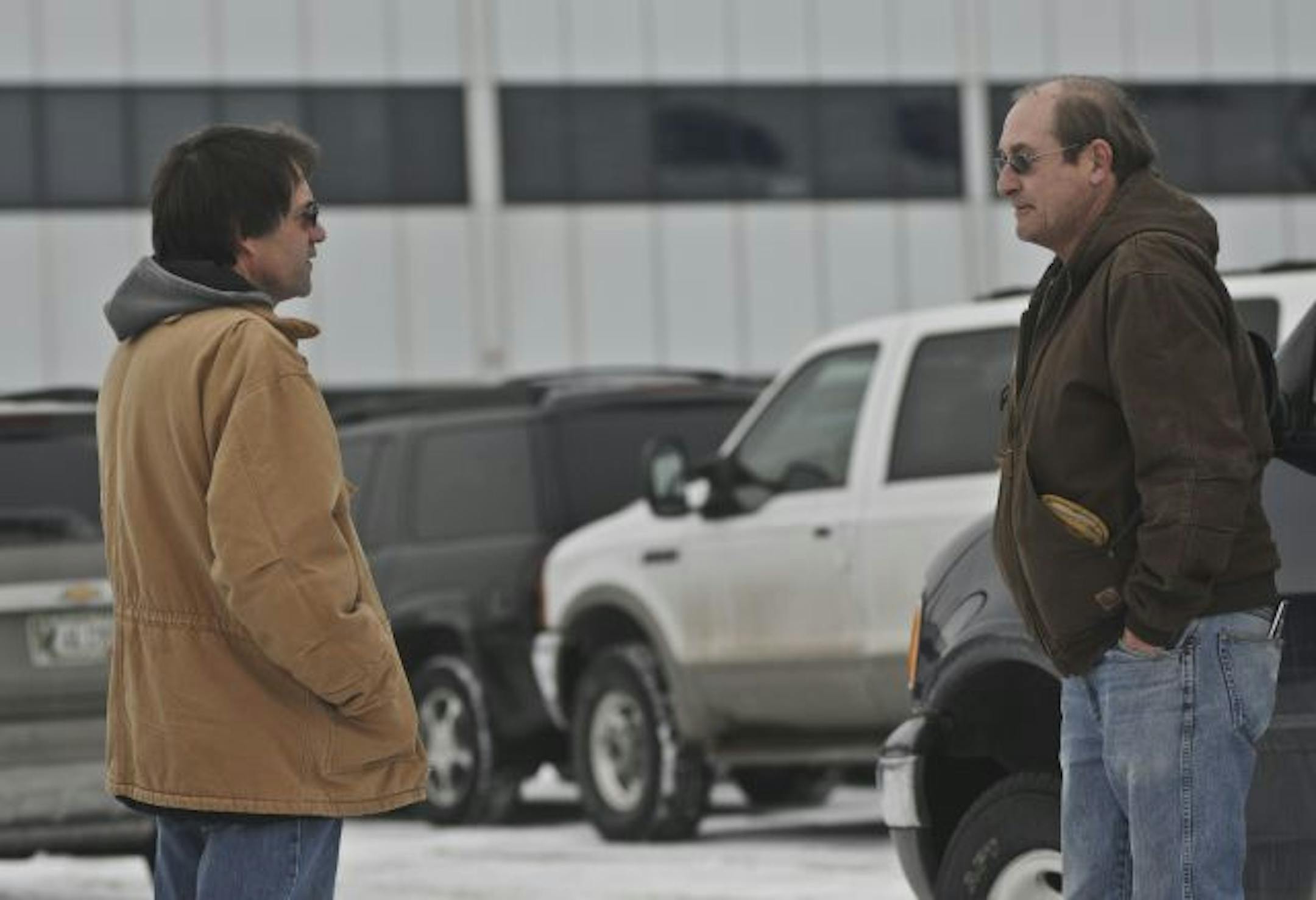 Clark Schwantes, left, who has worked for 10 years at Hutchinson Technology and Ron Lueck, who has worked there for 18 years, talked in the parking lot after an informational meeting Tuesday announcing the layoffs.
