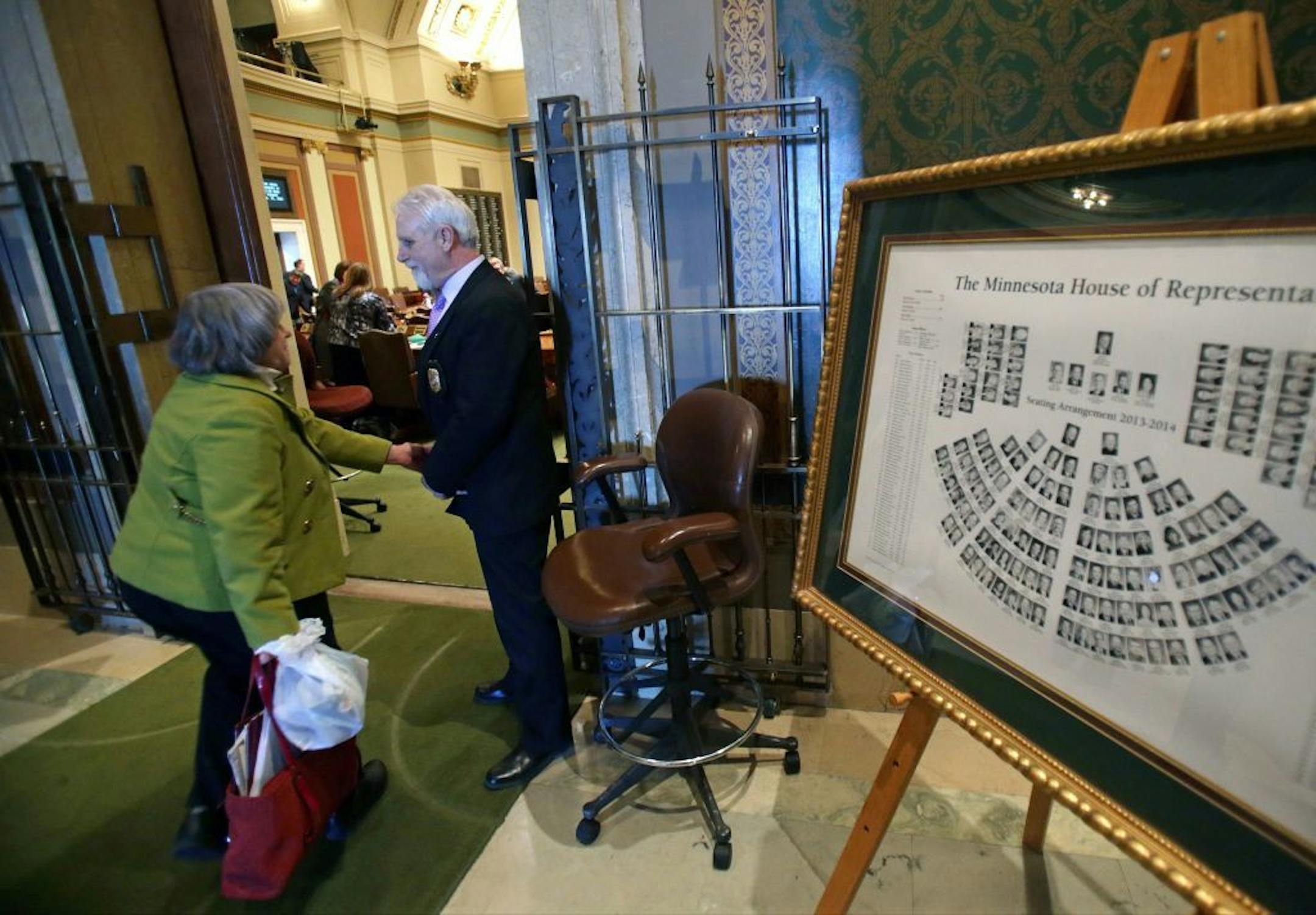 ADVANCE FOR MONDAY, DEC. 15 - In this Feb. 25, 2014 file photo sergeant-at-arms Sam Samuelson, right, stands outside the House chamber as he welcomed lawmakers back as the 2014 Minnesota Legislature convened in St. Paul, Minn. A new job description would require Minnesota�s chief sergeant-at-arms to have a law enforcement background, a change being undertaken partly to improve security and partly to do away with a patronage tradition.