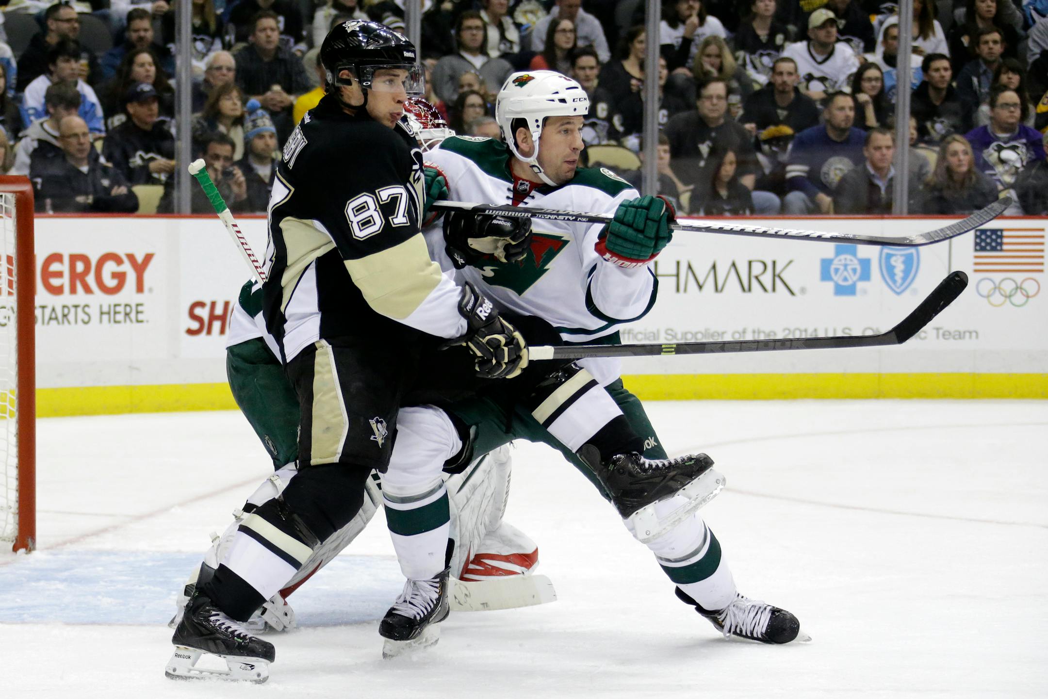 Minnesota Wild's Keith Ballard (2) tries to clear Pittsburgh Penguins' Sidney Crosby (87) from in front of Minnesota Wild goalie Niklas Backstrom (32) during the second period of an NHL hockey game in Pittsburgh Thursday, Dec. 19, 2013. The Penguins won 5-2. (AP Photo/Gene J. Puskar)