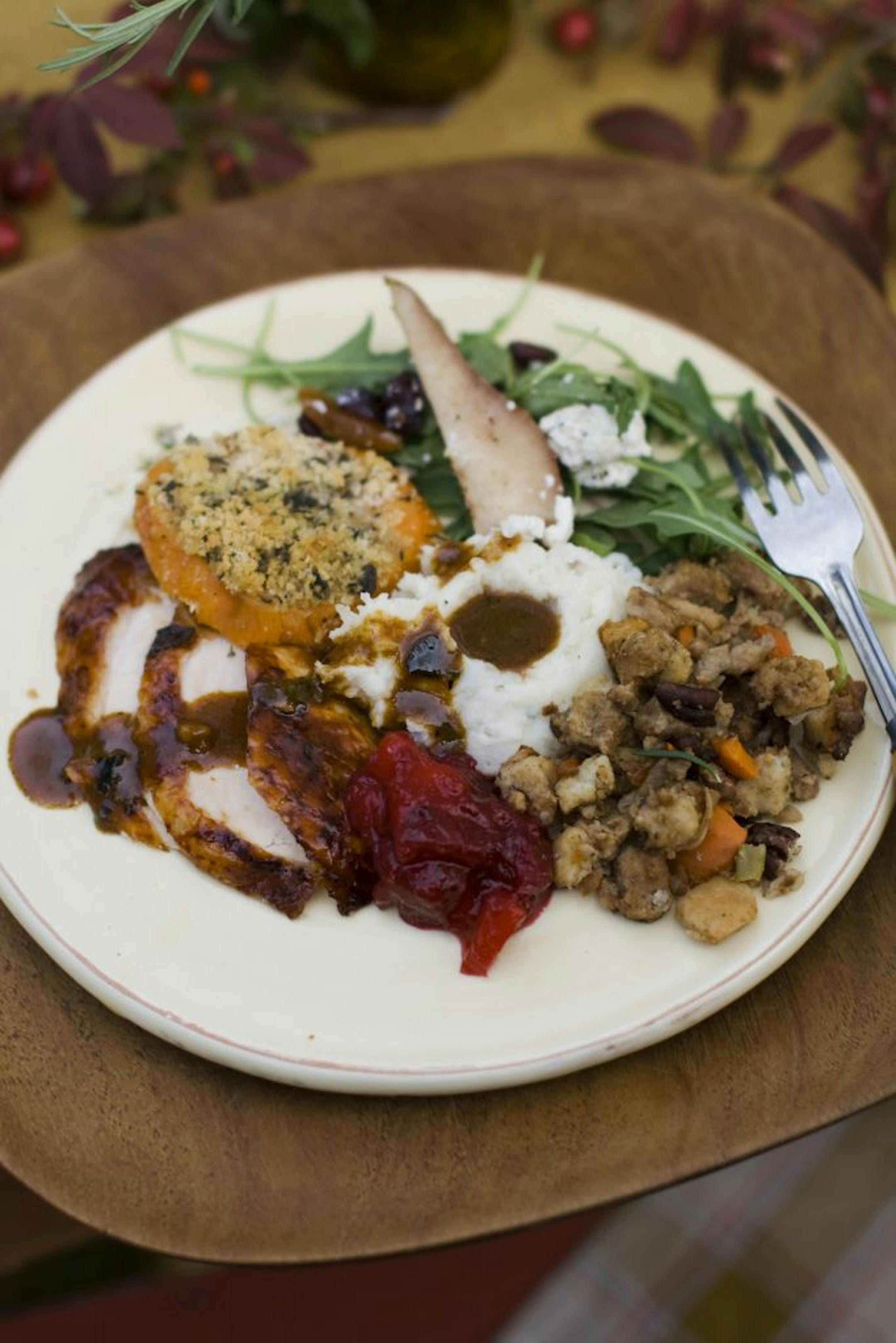 In this image taken on Oct. 8, 2012, a Thanksgiving dinner plate of cider brined turkey with sage gravy, peach cranberry sauce, sour cream and chive mashed potatoes, sausage pecan stuffing, arugula pear salad with pomegranate vinaigrette and goat cheese and herb crusted sweet potatoes is shown in Concord, N.H.