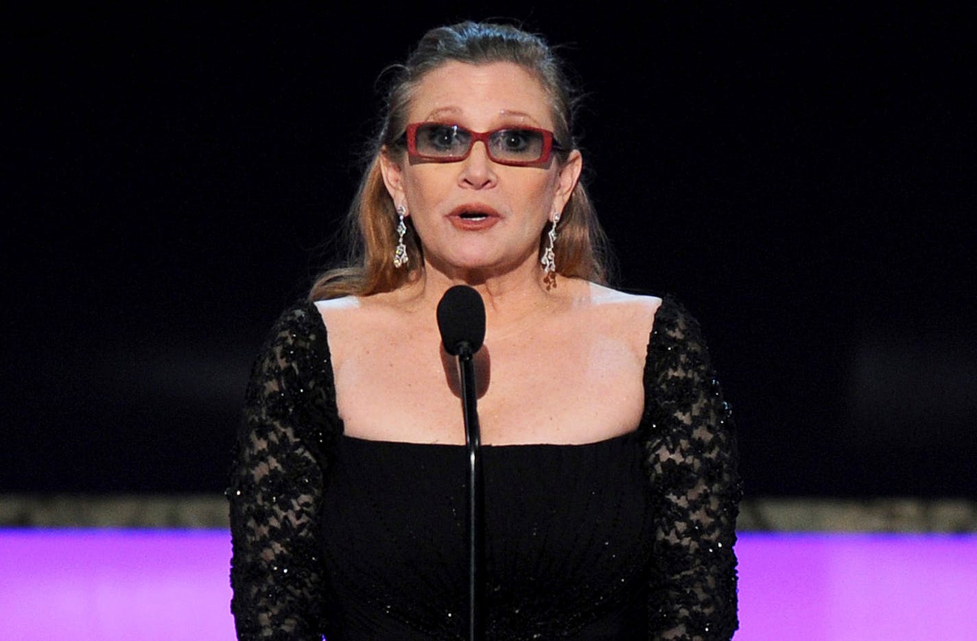 FILE - In this Sunday, Jan. 25, 2015 file photo, Carrie Fisher presents the life achievement award on stage at the 21st annual Screen Actors Guild Awards at the Shrine Auditorium in Los Angeles. Fisher has reportedly been transported to a hospital after suffering a severe medical emergency on a flight Friday, Dec. 23, 2016. (Photo by Vince Bucci/Invision/AP, File)