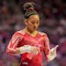 Suni Lee sprays her hands before competing on the uneven bars during the women's U.S. Olympic Gymnastics Trials Sunday, June 27, 2021, in St. Louis. (