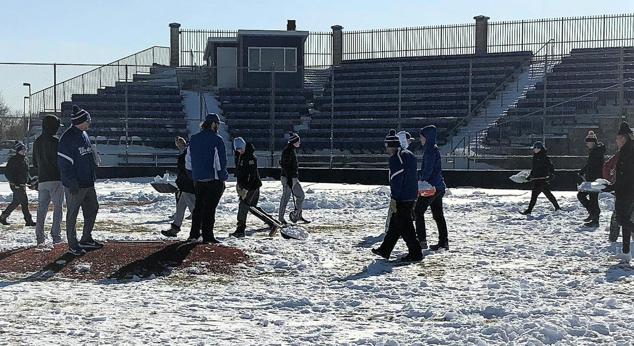 Woodbury baseball teams shoveling off its field