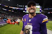 Minnesota Vikings quarterback Kirk Cousins (8) smiles wearing a chain from Minnesota Vikings wide receiver Justin Jefferson (18).